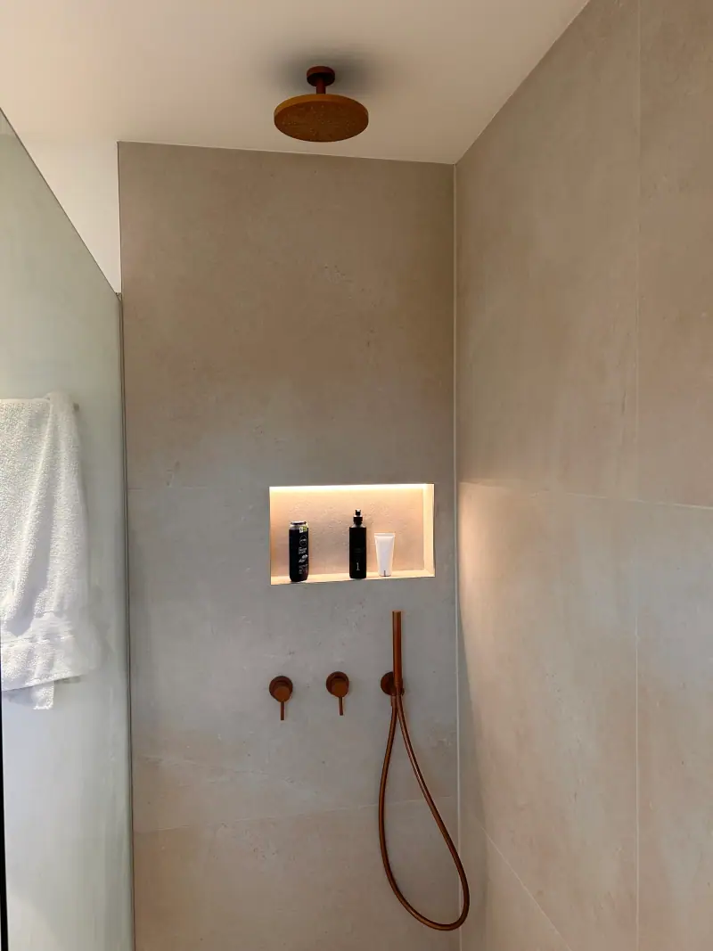 Dusche nach der Badsanierung mit beleuchteter Wandnische und Armaturen unter Putz