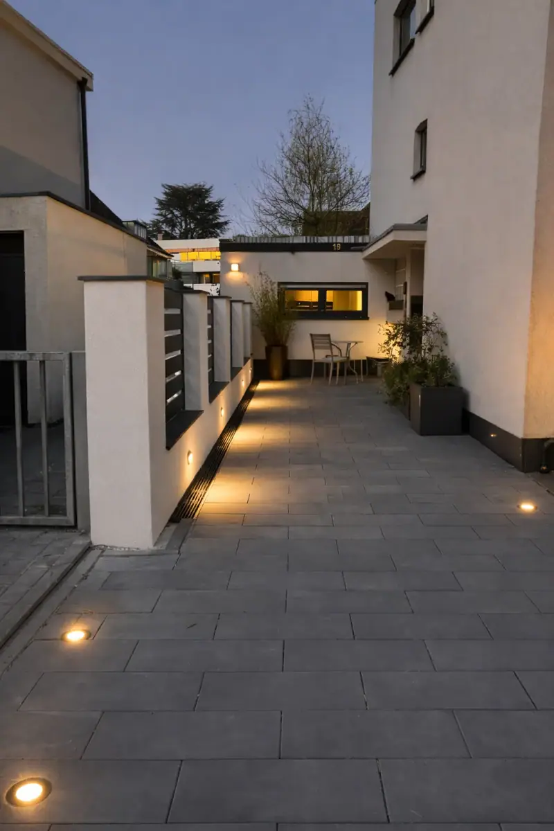 Hof am Abend mit Bodeneinbauleuchten entlang des Weges