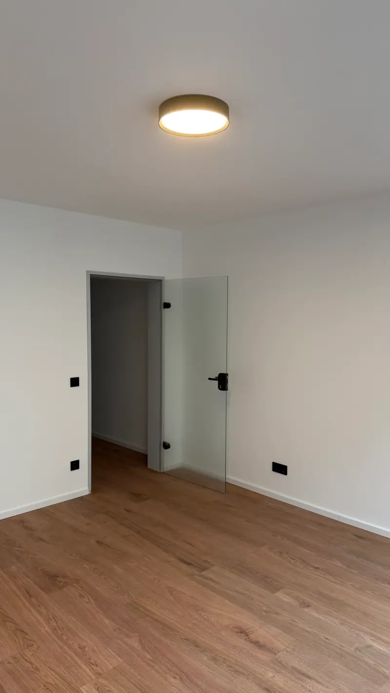 Saniertes Zimmer mit runder Deckenleuchte und neuen Steckdosen