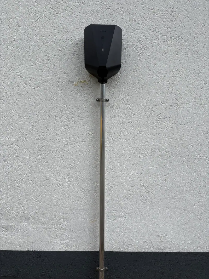 Wallbox auf einem Edelstahlständer vor einer Hauswand